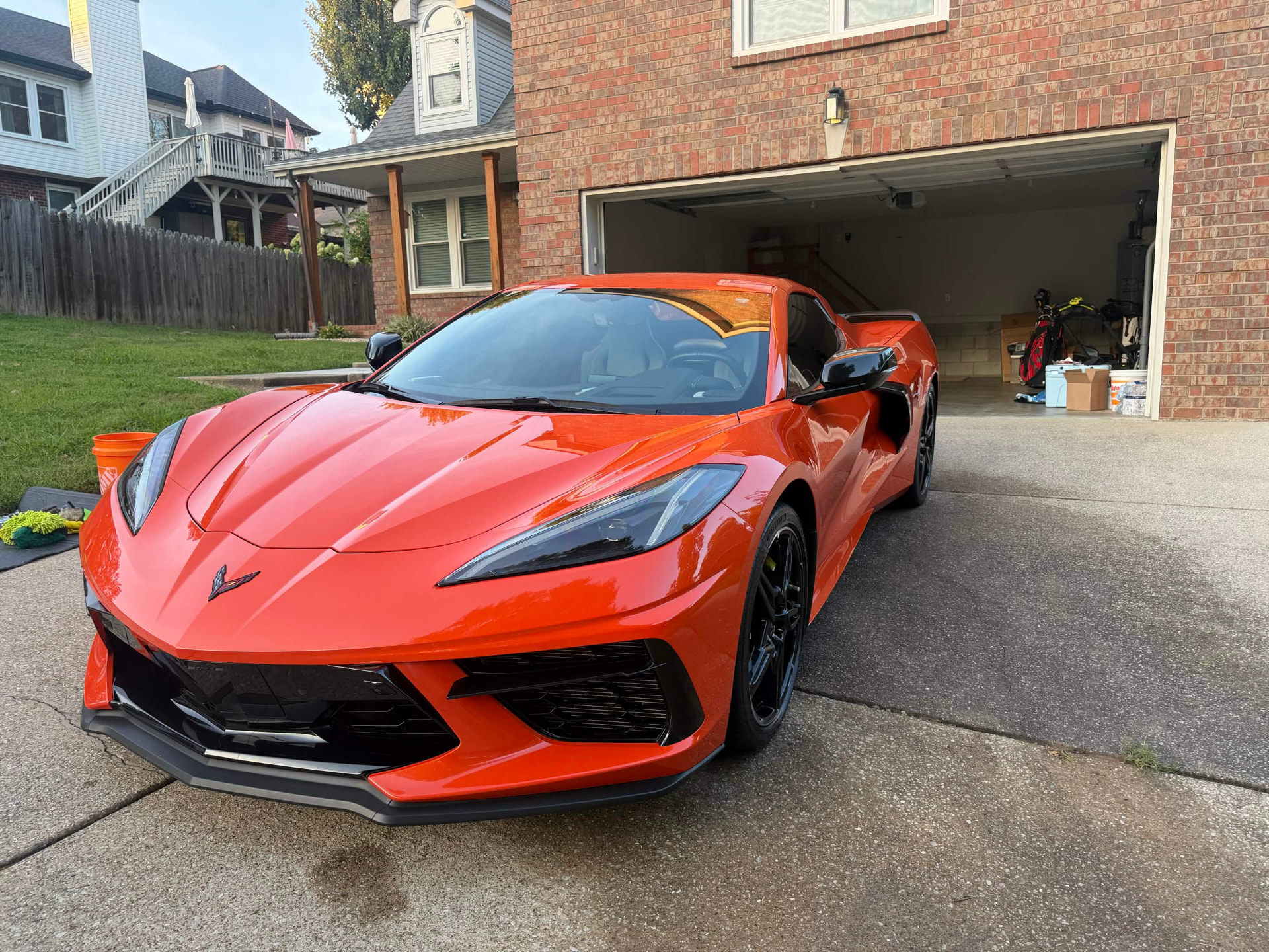 Orange paint and gloss-black trim on a Corvette C8 Stingray, detailed to a deep, mirror-like shine.